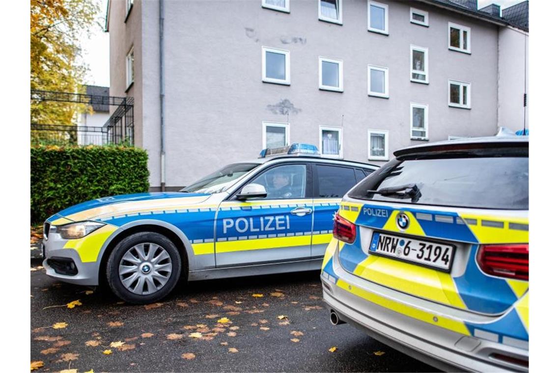 Polizeifahrzeuge vor dem Mehrfamilienhaus in Detmold, in dem eine 15-Jährige ihren dreijährigen Halbbruder erstochen haben soll. Foto: Guido Kirchner/dpa