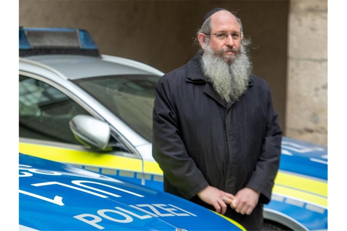 Polizeirabbiner Shneur Trebnik steht zwischen zwei Streifenwagen. Foto: Stefan Puchner/dpa/Archivbild