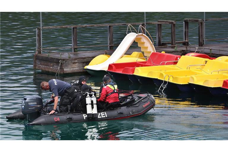 Polizeitaucher fahren in einem Schlauchboot, vor den Tretbooten eines geschlossenen Bootsverleihs, hinaus auf den Eibsee.