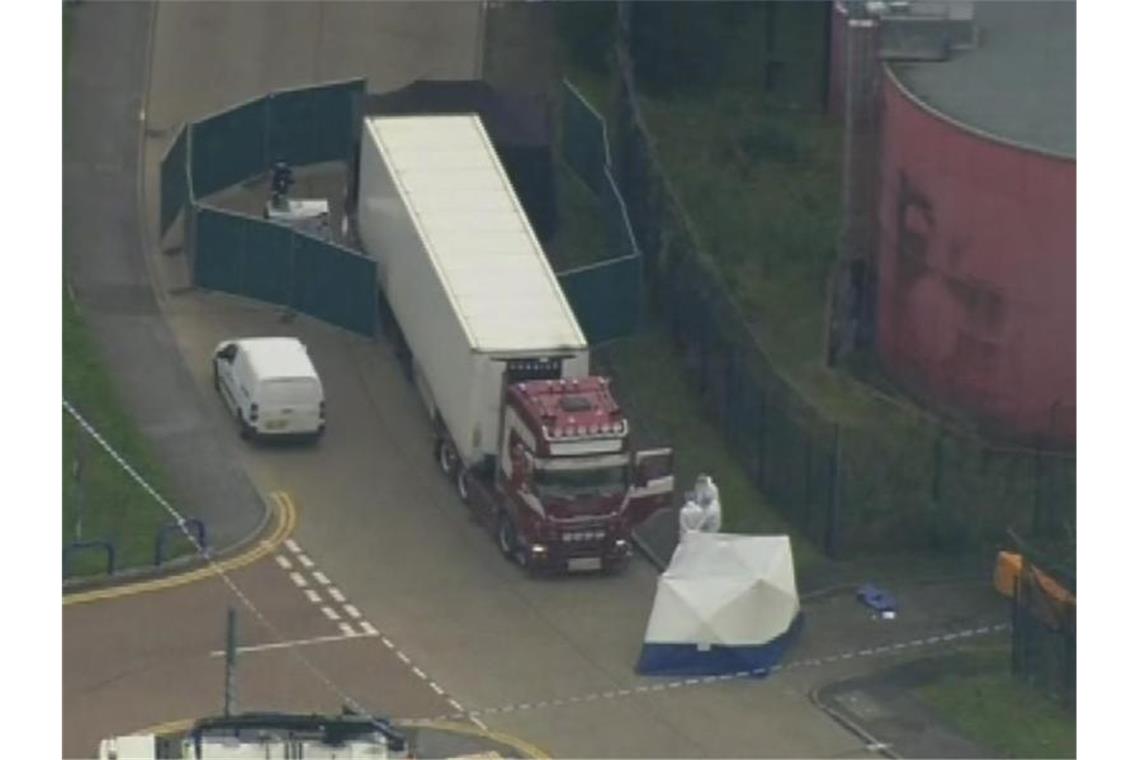 Außenministerium in Peking: Tote im Lkw-Anhänger aus China Polizisten am Fundort der 39 Leichen. Foto: Uk Pool/UK Pool/AP/dpa
