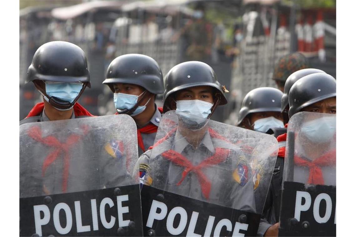 Polizisten am Rande einer Anti-Putsch-Demonstration in Mandalay hinter einer Strassenbarrikade. Foto: Aung-Shine/AP/dpa
