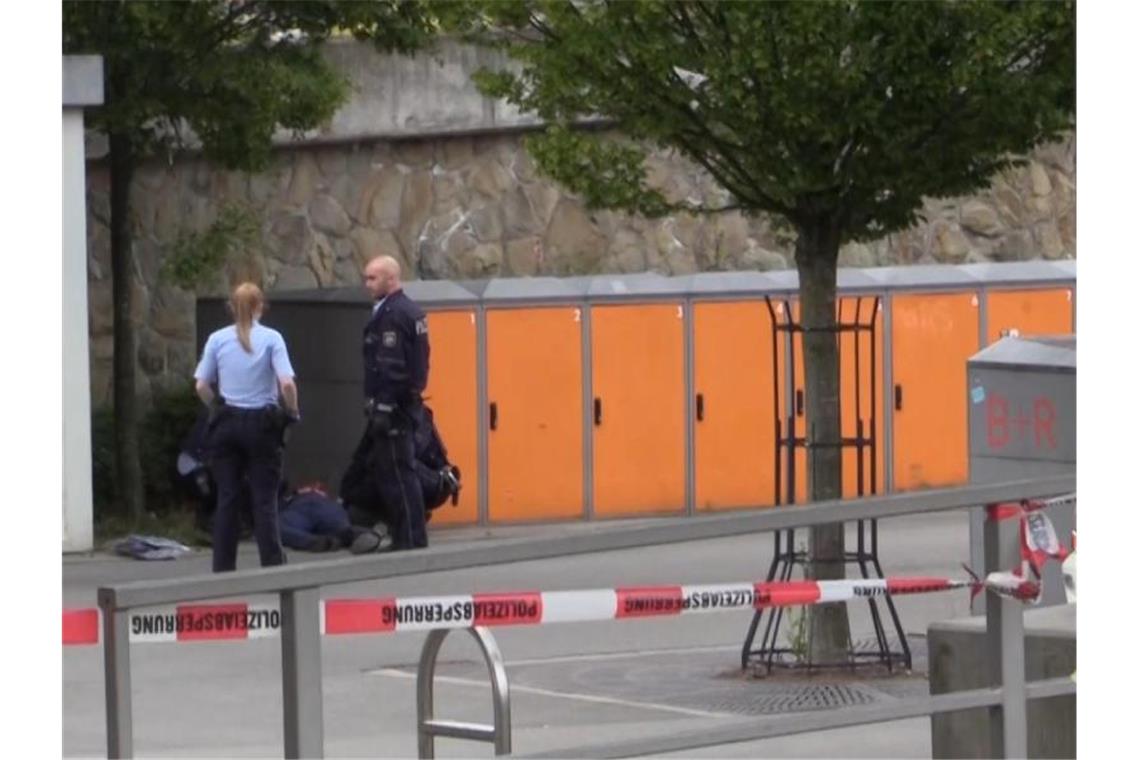 Nach Messerattacke mit zwei Toten: Verdächtiger in U-Haft Polizisten am Stadtbahnhof in Iserlohn neben dem am Boden liegenden Tatverdächtigen. Foto: Frank Bauermann/TNN