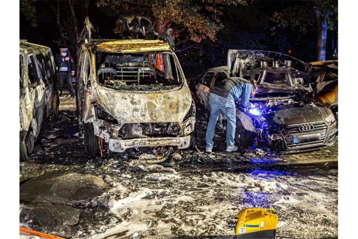 Fünf Autos ausgebrannt: Fahndung mit Hubschrauber Polizisten an den verbrannten Fahrzeugen in Stuttgart. Foto: Alexander Hald/VMD-Images/dpa