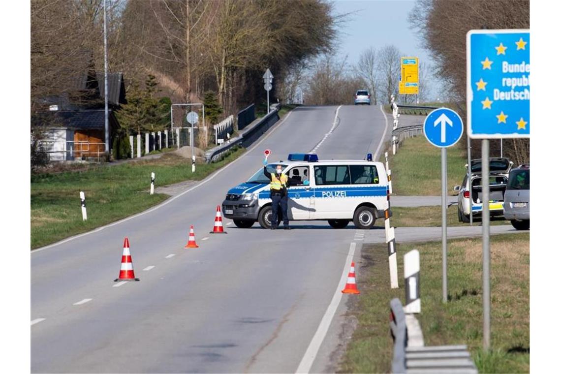 Polizisten an der Bundesstraße 512 in der Nähe von Neuhaus am Inn an einer Kontrollstelle an der Grenze zu Österreich. Foto: Sven Hoppe/dpa