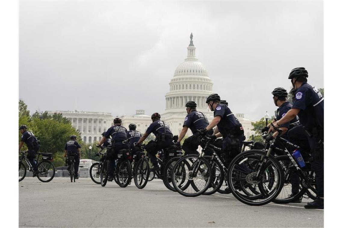 Polizisten auf Fahrrädern beobachten eine Kundgebung in der Nähe des Kapitols. Foto: Jose Luis Magana/AP/dpa