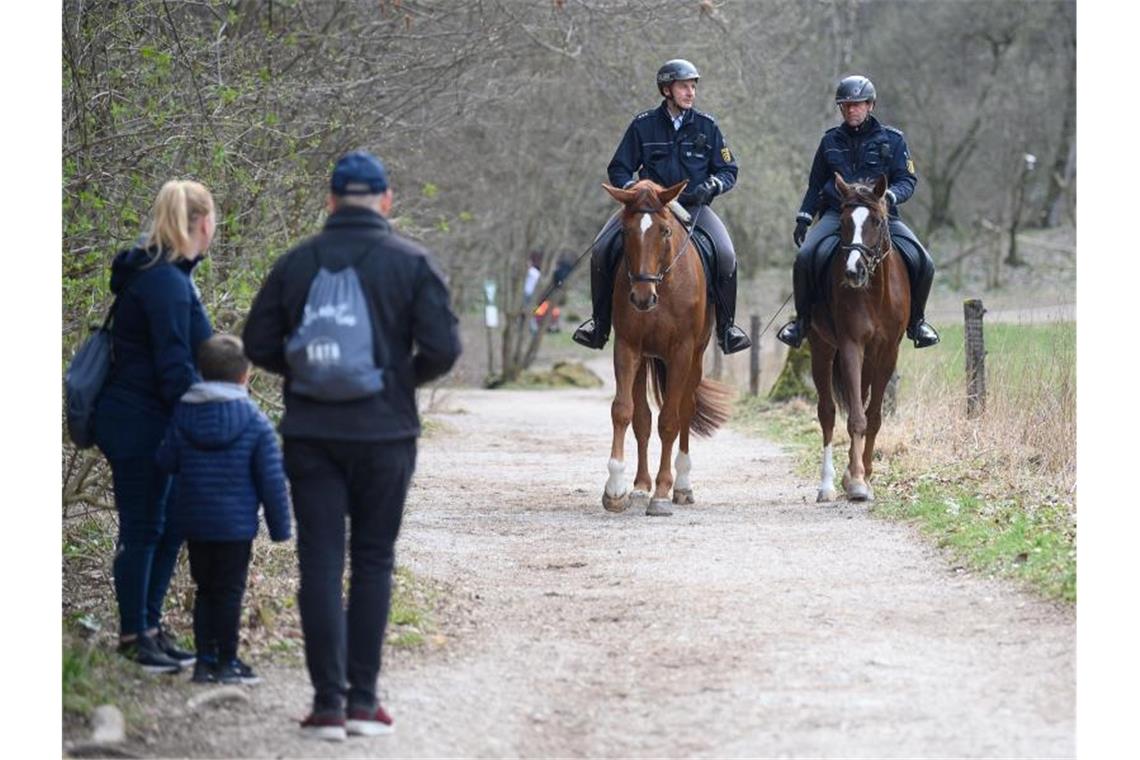 Etliche Verstöße gegen Verbote der Corona-Verordnung Polizisten auf Pferden reiten über einen Feldweg. Foto: Sebastian Gollnow/dpa/Archivbild