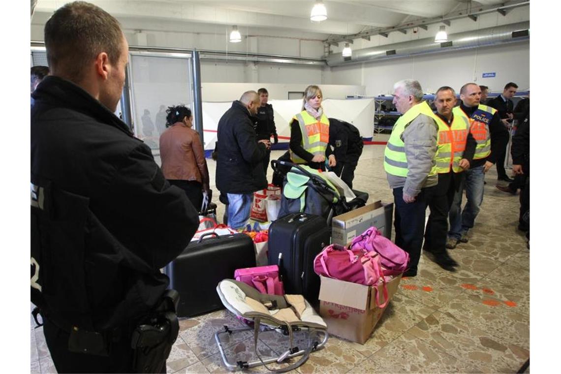 Polizisten begleiten abgelehnte Asylbewerber zu einem Terminal. Foto: Sebastian Willnow