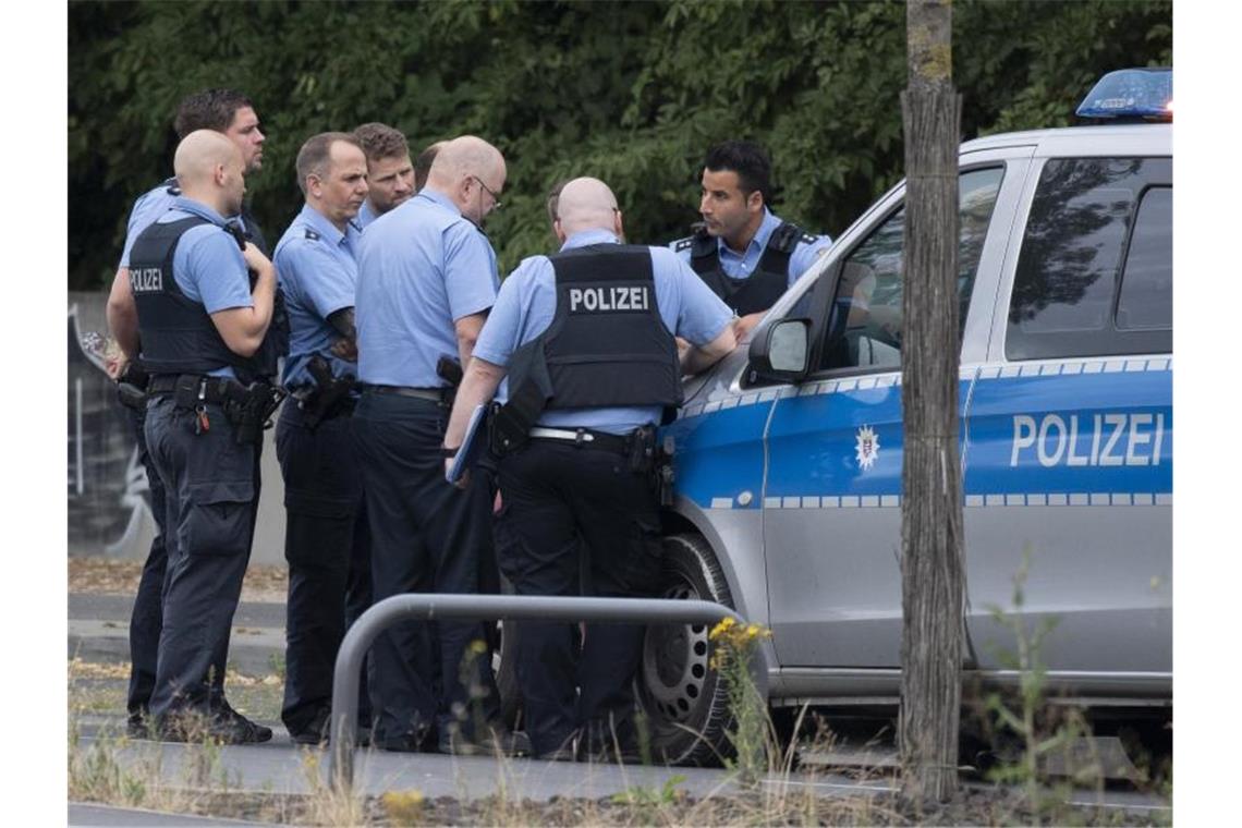 Polizisten bei einer Lagebesprechung in unmittelbarer Nähe des Blindgängers. Foto: Boris Roessler