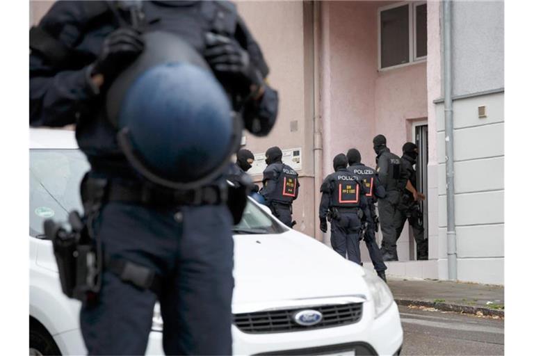 Polizisten bei einer Razzia im Zusammenhang mit der Attacke auf einen Teilnehmer einer Corona-Demo. Foto: Julian Rettig/dpa