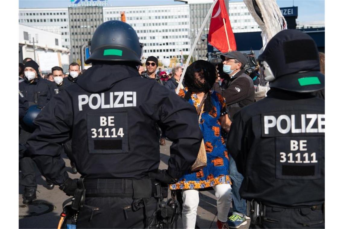 Polizisten beobachten am Alexanderplatz in Berlin eine Demonstration gegen die Corona-Auflagen. Foto: Paul Zinken/dpa