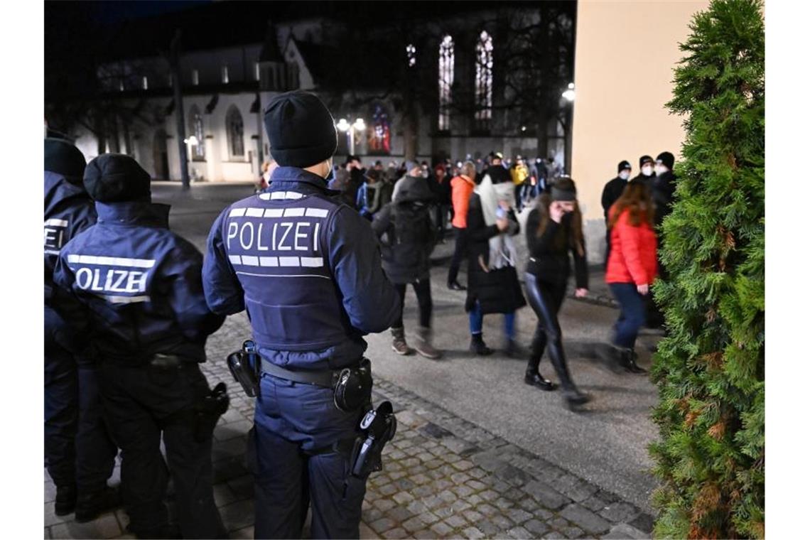 Polizisten beobachten „Spaziergänger“ in Ravensburg. Foto: Felix Kästle/dpa