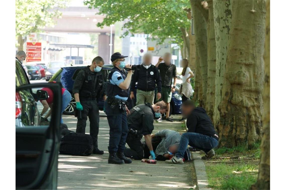 Vor Prozess um Angriff bei Corona-Demo: Weitere Ermittlungen Polizisten betreuen einen verletzten Mann, der auf dem Weg zu einer Corona-Demo zusammengeschlagen wurde. Foto: Andreas Rosar/Andreas Rosar Fotoagentur-Stuttg/dpa/Archivbild