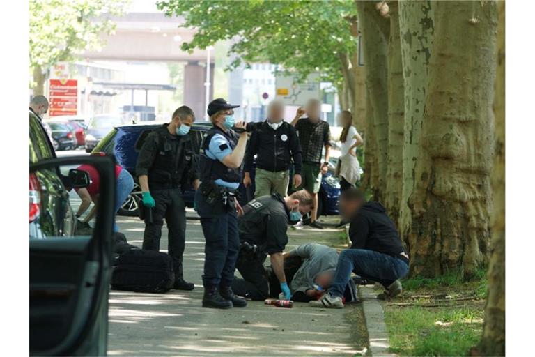 Polizisten betreuen einen verletzten Mann, der auf dem Weg zu einer Corona-Demo zusammengeschlagen wurde. Foto: Andreas Rosar/Andreas Rosar Fotoagentur-Stuttg/dpa/Archivbild