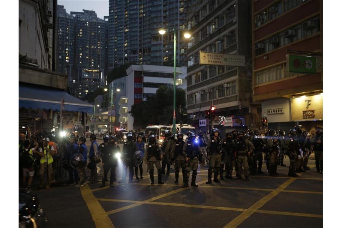 Demonstrant angeschossen: Neue Gewaltwelle in Hongkong Polizisten blockieren eine Straße in Hongkong. Foto: Dita Alangkara/AP/dpa