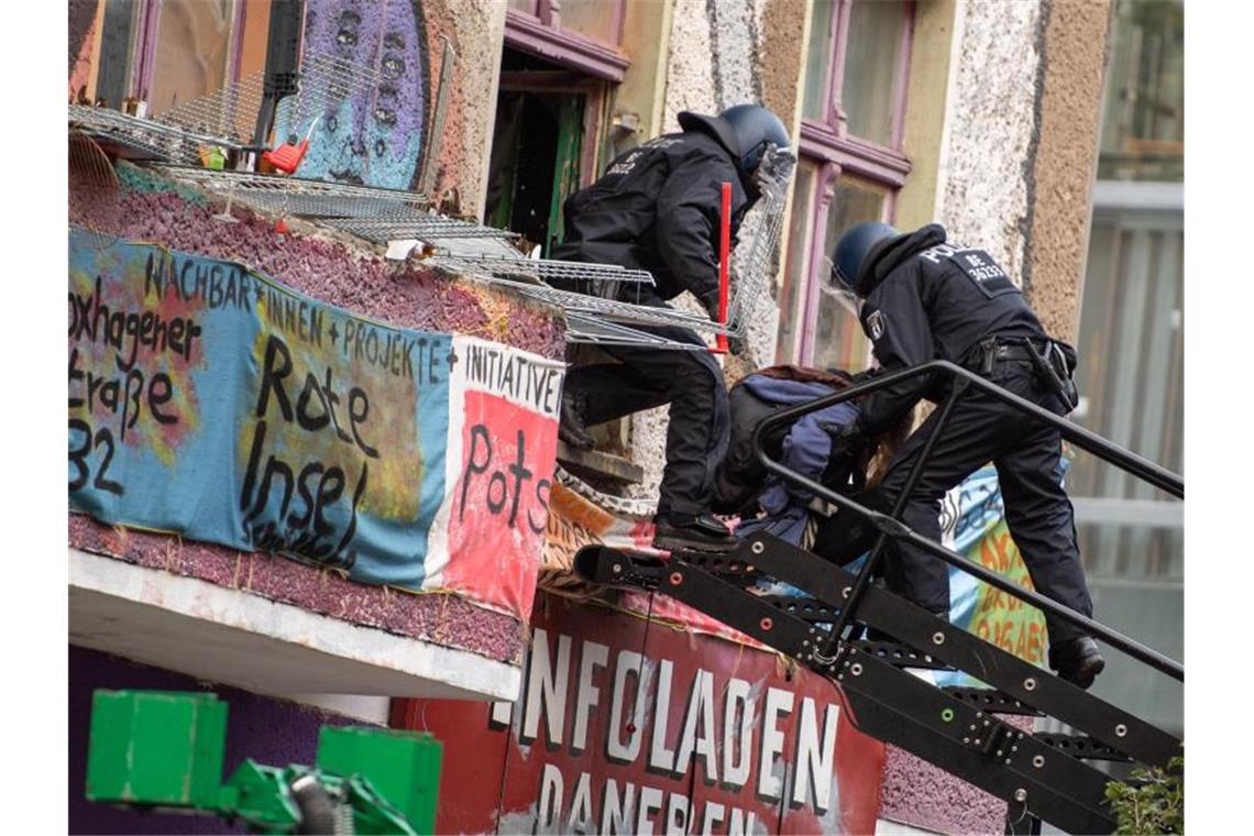 Polizisten bringen bei der Räumung eine Bewohnerin über eine Treppe durch ein Fenster des besetzten Hauses „Liebig 34“ an der Ecke Liebigstraße - Rigaer Straße in Berlin. Foto: Christophe Gateau/dpa