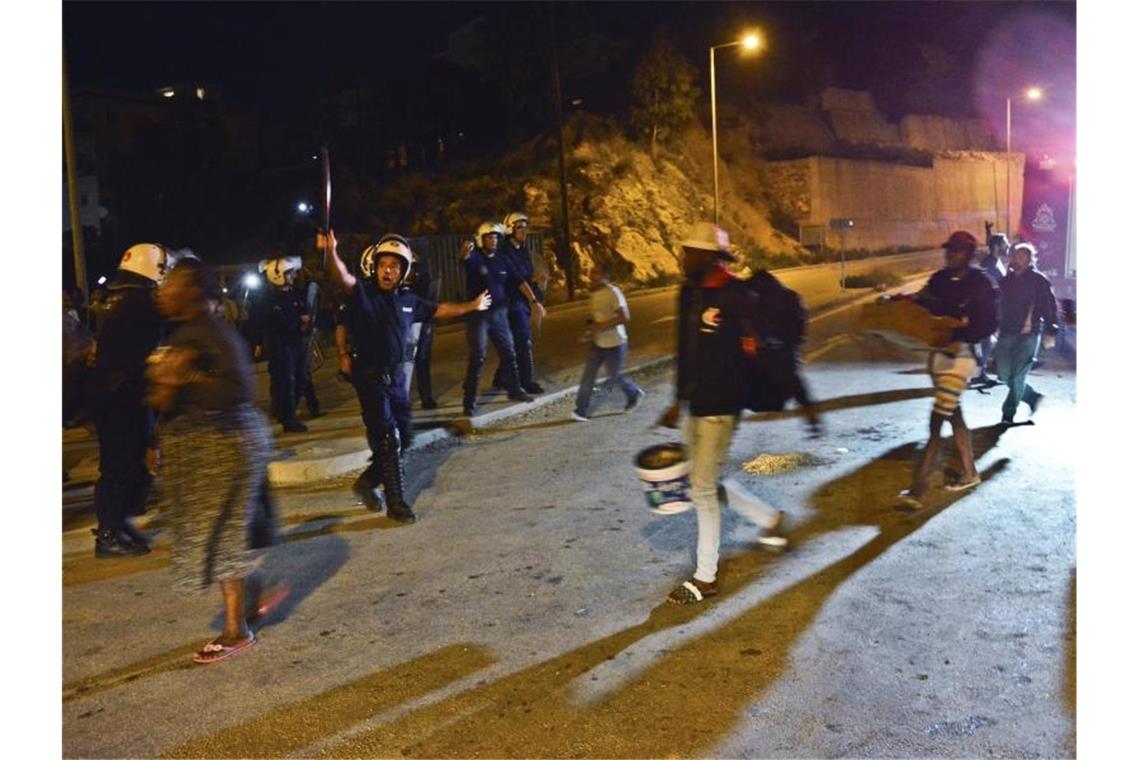 Polizisten bringen Menschen aus dem völlig überfüllten Migrantenlager auf der griechischen Insel Samos. Foto: Michael Svarnias/AP/dpa