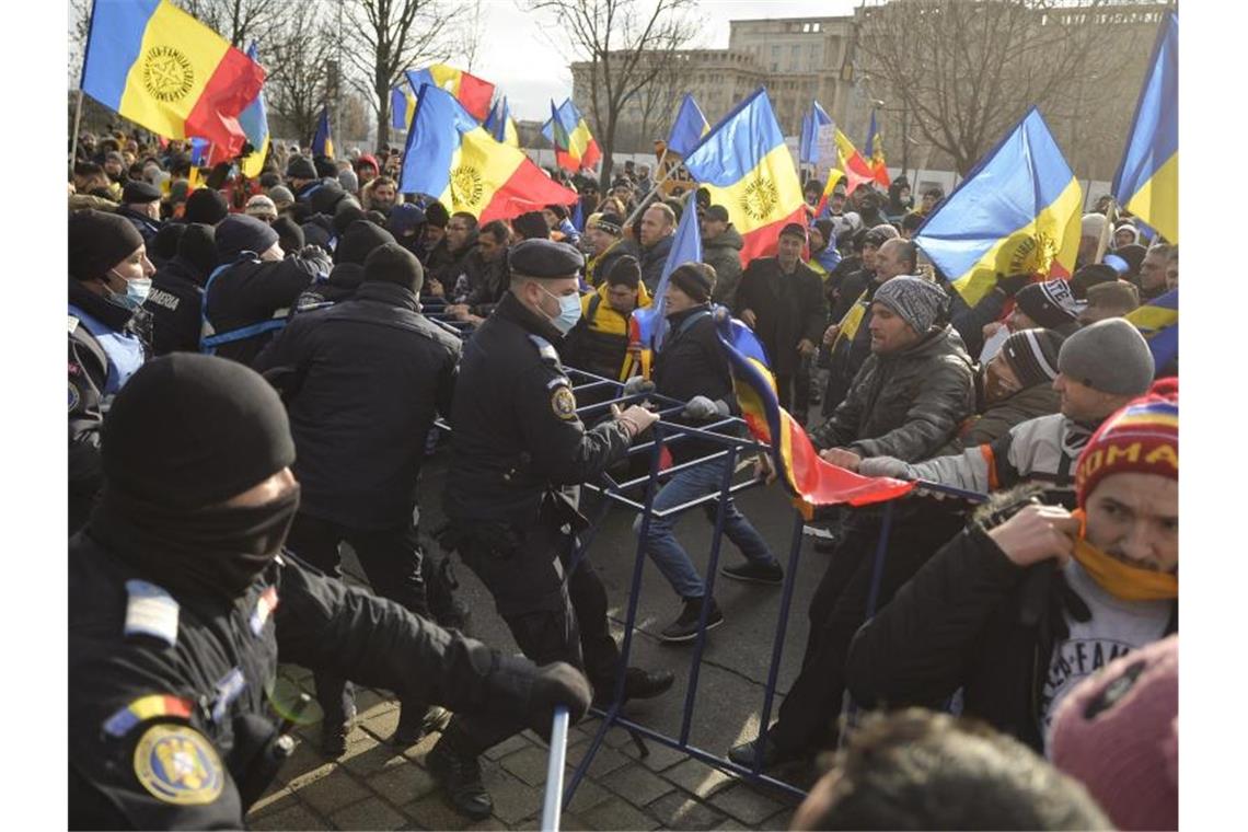 Polizisten der Bereitschaftspolizei ringen vor dem Parlamentspalast in Bukarest mit Demonstranten. Foto: Alexandru Dobre/AP/dpa