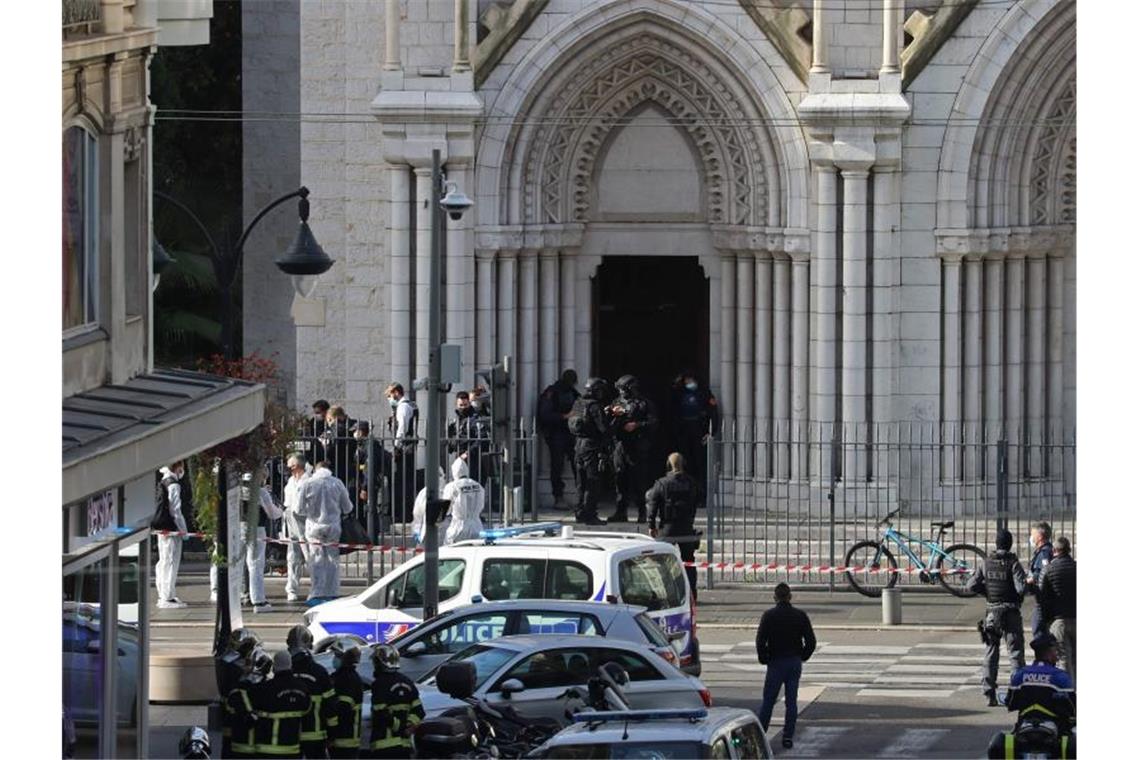 Polizisten der Eliteeinheit Raid treffen ein, um die Kirche Notre-Dame nach einem Messerangriff zu durchsuchen. Foto: Valery Hache/AFP/dpa