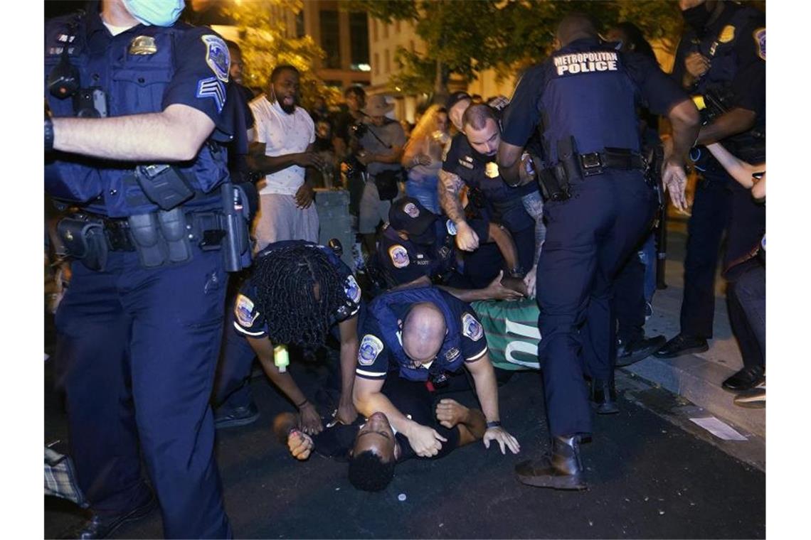 Polizisten drücken einen Demonstranten am Black Lives Matter Plaza in Washington auf die Straße. Foto: Julio Cortez/AP/dpa