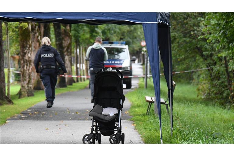 Polizisten ermitteln an einem Abgesperrten Bereich eines Gehwegs, auf dem eine Kinderkarre steht. Sechs Monate nach dem Ertrinkungstod eines Sechsjährigen in Österreich steht sein Vater unter dringendem Mordverdacht.
