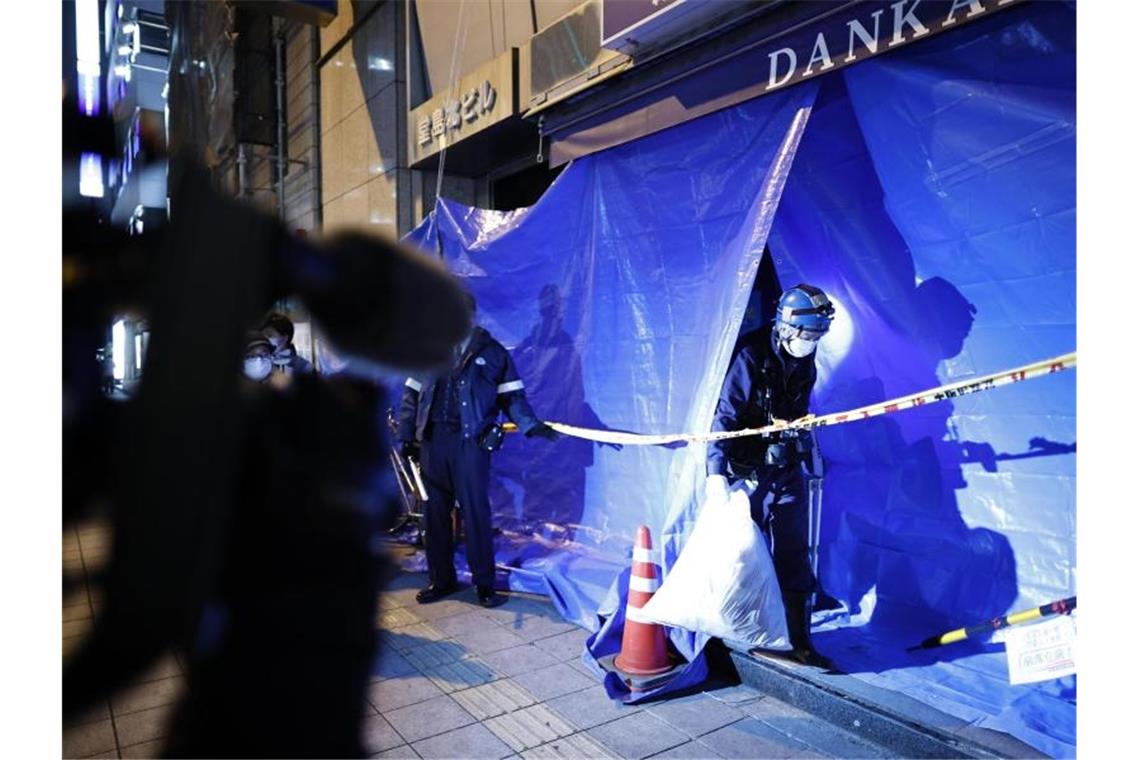 Brandkatastrophe in Japan: Tat vorbereitet? Polizisten ermitteln in dem abgesperrten Mehrfamilienhaus in Osaka, in dem es zu dem tödlichen Brand gekommen ist. Foto: ---