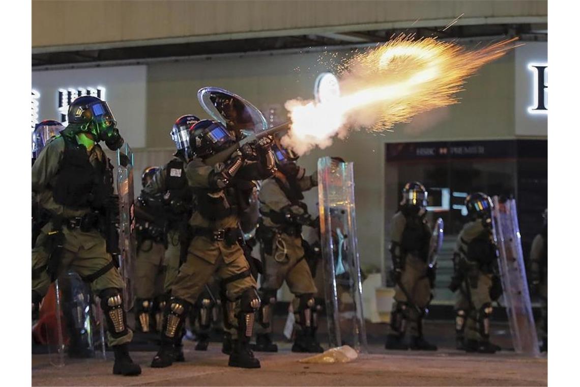 Heftige Zusammenstöße in Hongkongs Flughafen Polizisten feuern am Wochenende in Hongkong Tränengas auf Demonstranten. Foto: Kin Cheung/AP