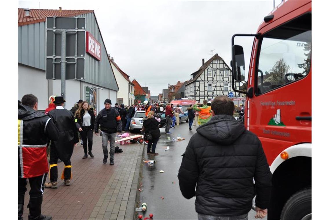 Polizisten, Feuerwehrleute und Passanten stehen an der Stelle, an der das Auto in eine Menschenmenge gefahren war. Foto: Elmar Schulten/XinHua/dpa