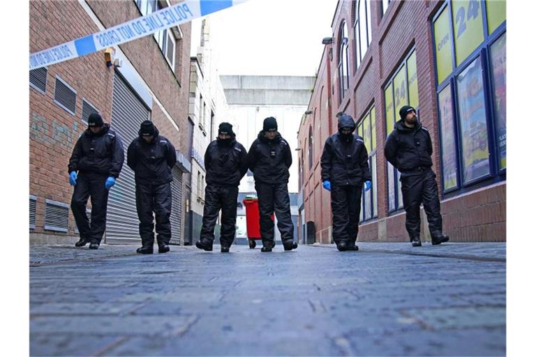 Polizisten führen eine Durchsuchung in der Nähe des Tatorts im Stadtzentrum durch, nachdem ein 12-jähriges Mädchen an den Folgen eines Angriffs gestorben ist. Foto: Peter Byrne/PA Wire/dpa