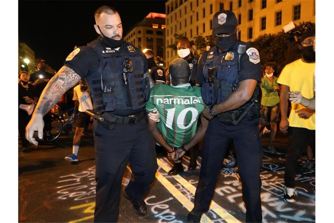 Polizisten führen einen Demonstranten während eines Protests gegen US-Präsident Trump ab. Foto: Julio Cortez/AP/dpa