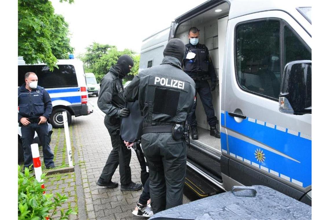Großeinsatz gegen Drogenszene im Rhein-Neckar-Kreis Polizisten führen einen Mann zu einem Einsatzfahrzeug. Foto: Rene Priebe/pr-video/dpa