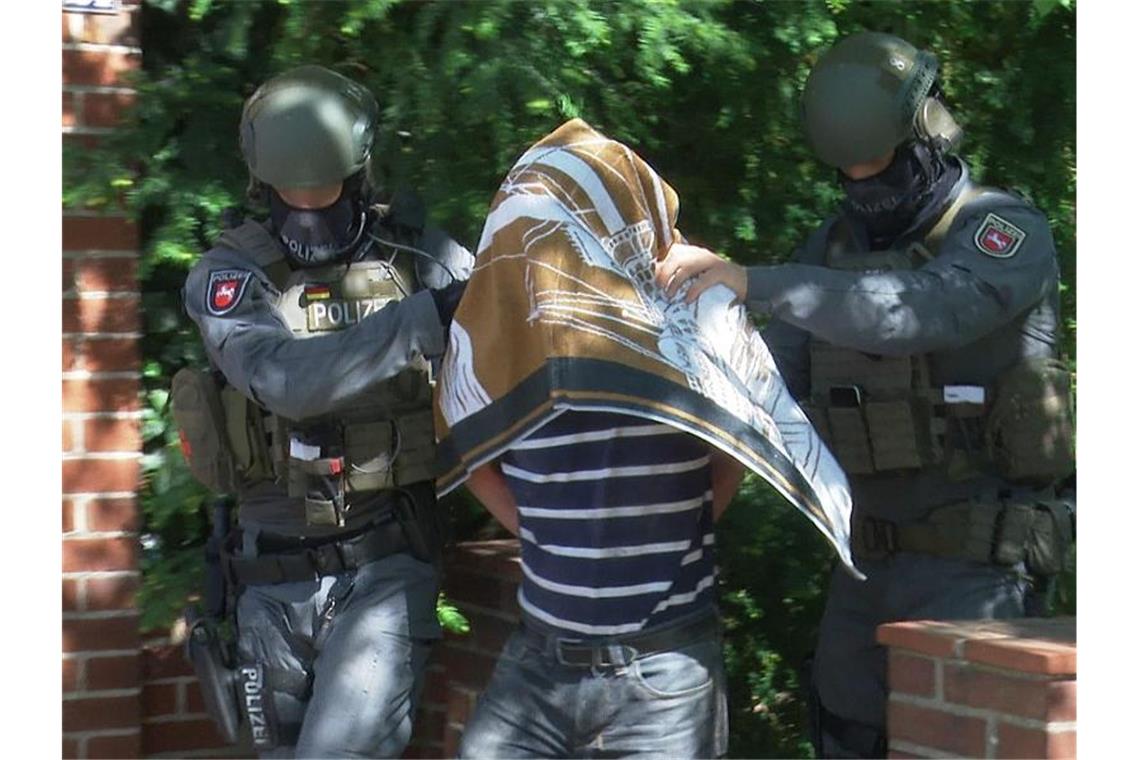 Polizisten führen einen Verdächtigen in Handschellen ab. Foto: M. Schäfer/HannoverReporter.de/dpa