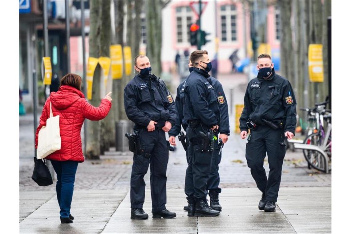 Polizisten führen in Mainz Maskenkontrollen durch. Wegen des bundesweiten Lockdown bleiben zahlreiche Geschäfte geschlossen. Foto: Andreas Arnold/dpa