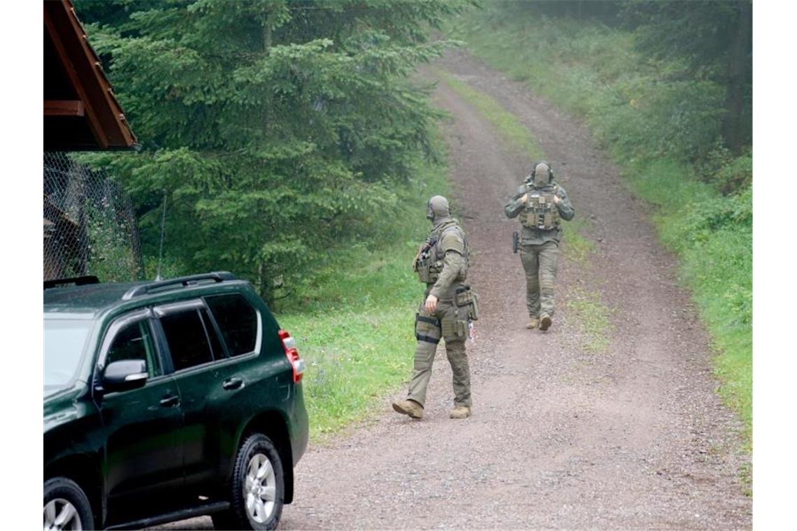 Polizisten gehen bei Oppenau durch ein Waldgebiet. Foto: Benedikt Spether/dpa