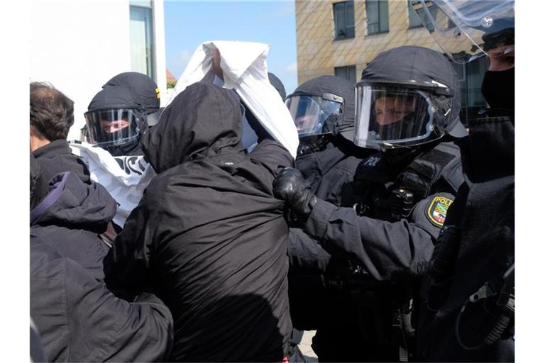 Polizisten gehen gegen Teilnehmer einer Protestaktion gegen eine AfD- Wahlkampfveranstaltung vor. In Sachsen-Anhalt wird am 06.06.2021 ein neuer Landtag gewählt. Foto: Sebastian Willnow/dpa-Zentralbild/dpa