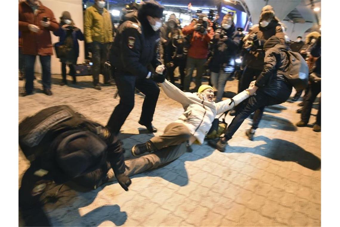Polizisten halten am Terminal des Flughafens Moskau-Wnukowo einen Mann fest, der auf die Ankunft des Oppositionsführers Nawalny wartet. Foto: Dmitry Serebryakov/AP/dpa
