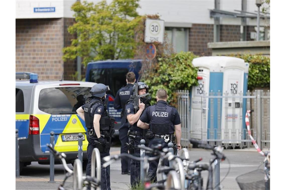 Drei Tote bei Kiel - Noch keine Aussage des Verdächtigen Polizisten in Schutzausrüstung stehen im Brauereiviertel in Kiel auf der Straße. Foto: Frank Molter/dpa