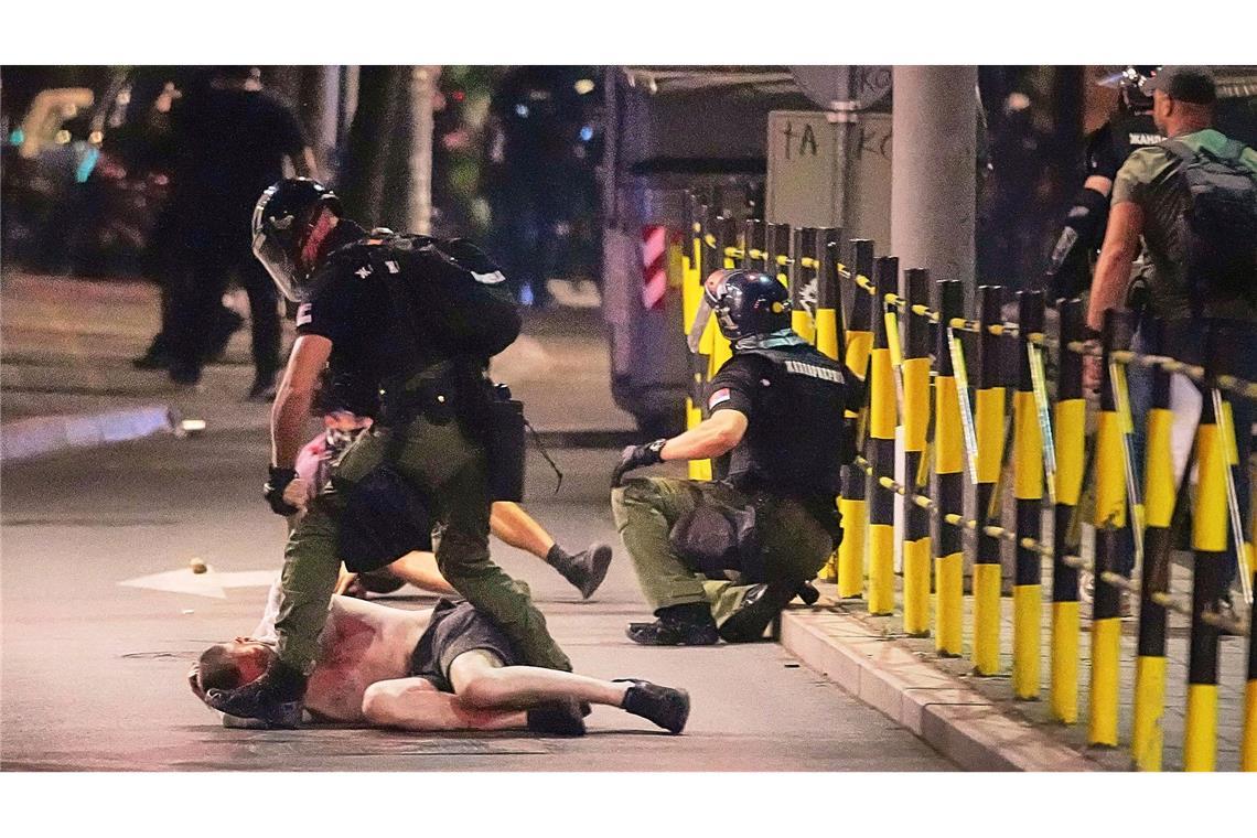 Bilder des Tages Polizisten in Schutzbekleidung nehmen einen Mann fest, nachdem sie Demonstranten am Ende einer Anti-Regierungs-Kundgebung angegriffen hatten, die auf eine vorgezogene Wahl drängten.
