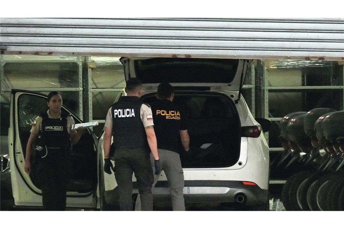 Polizisten in Schutzwesten untersuchen das Auto des erschossenen Staatsanwalts César Suárez.
