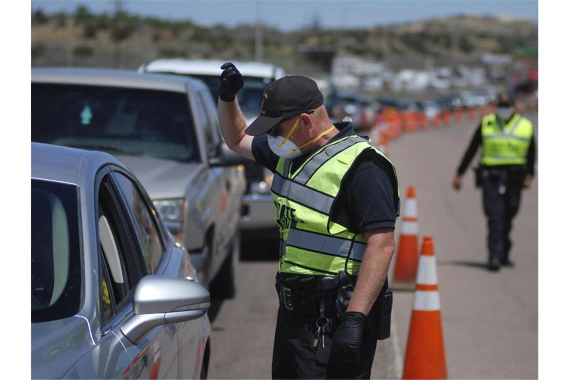 Polizisten kontrollieren im US-Bundesstaat New Mexico, ob nicht mehr als zwei Personen in den vorbeifahrenden Autos sitzen. Foto: Morgan Lee/AP/dpa
