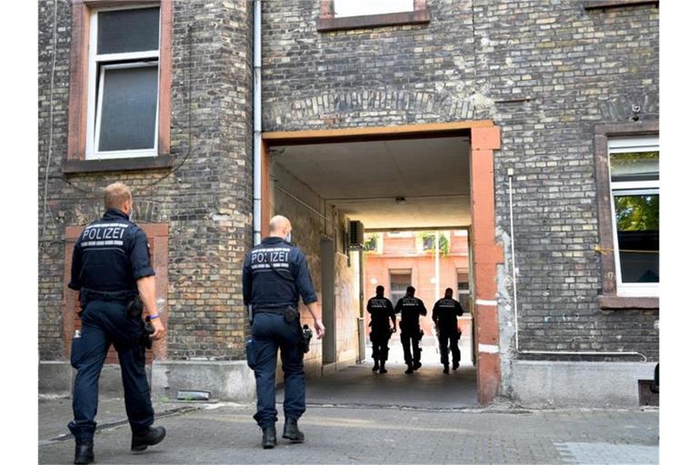 Polizisten kontrollieren und durchsuchen in der Innenstadt von Mannheim Immobilien. Foto: Rene Priebe/dpa