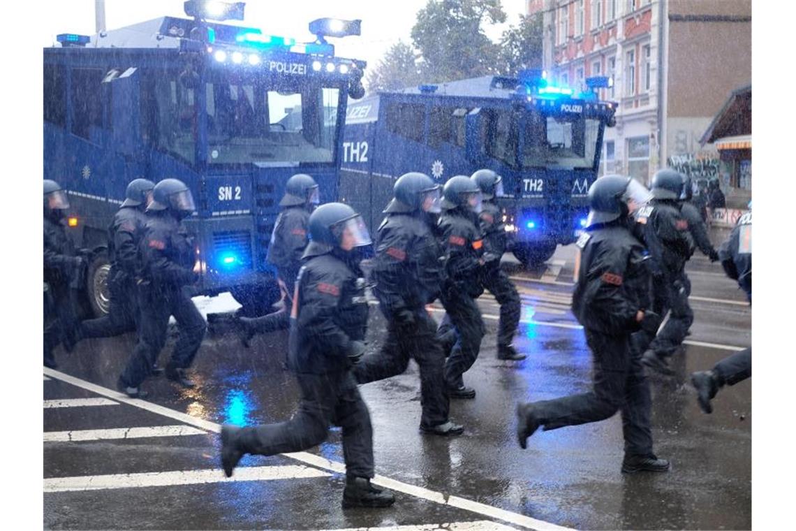 Brennende Barrikaden nach linker Demonstration in Leipzig Polizisten laufen über eine Kreuzung im Leipziger Stadtteil Connewitz. Foto: Sebastian Willnow/dpa-Zentralbild/dpa