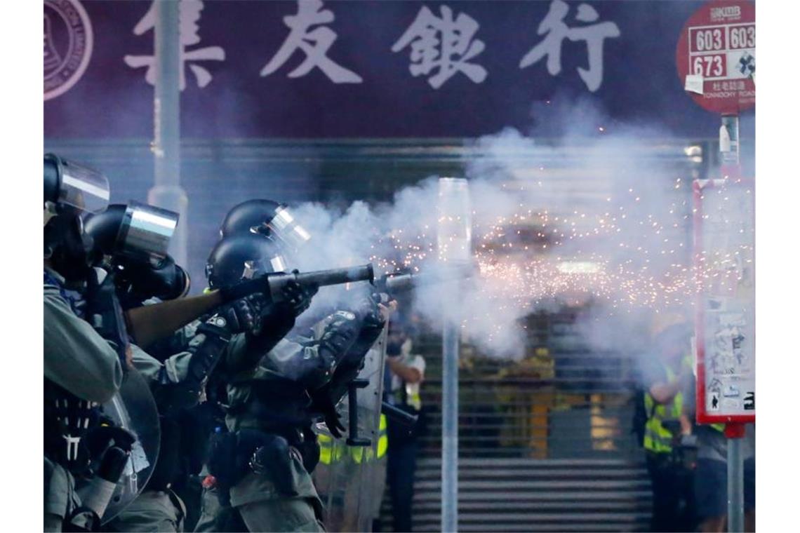 Polizisten mit Gasmasken schießen Tränengas auf Demonstranten. Foto: Dita Alangkara/AP/dpa
