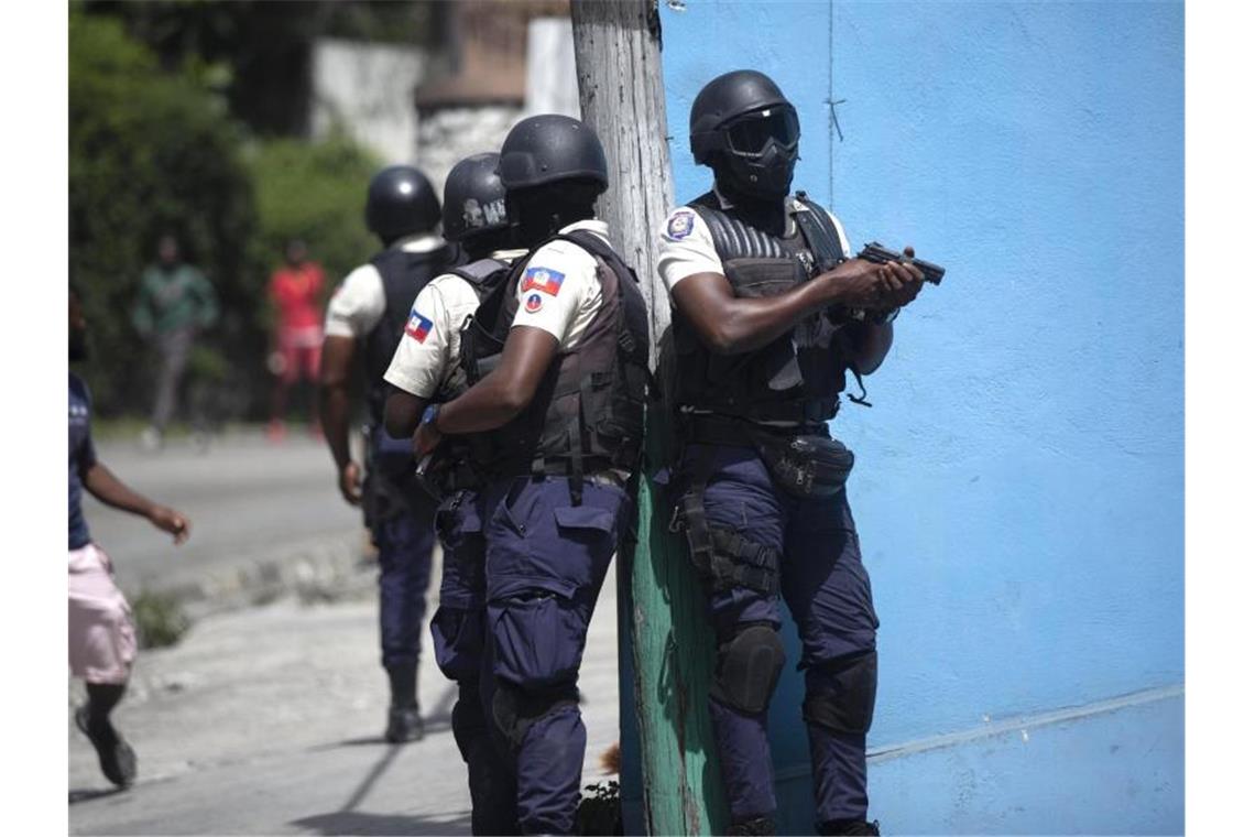 Polizisten mit gezogenen Waffen suchen nach Verdächtigen im Mordfall des haitianischen Präsidenten Jovenel Moise, in Port-au-Prince. Foto: Joseph Odelyn/AP/dpa