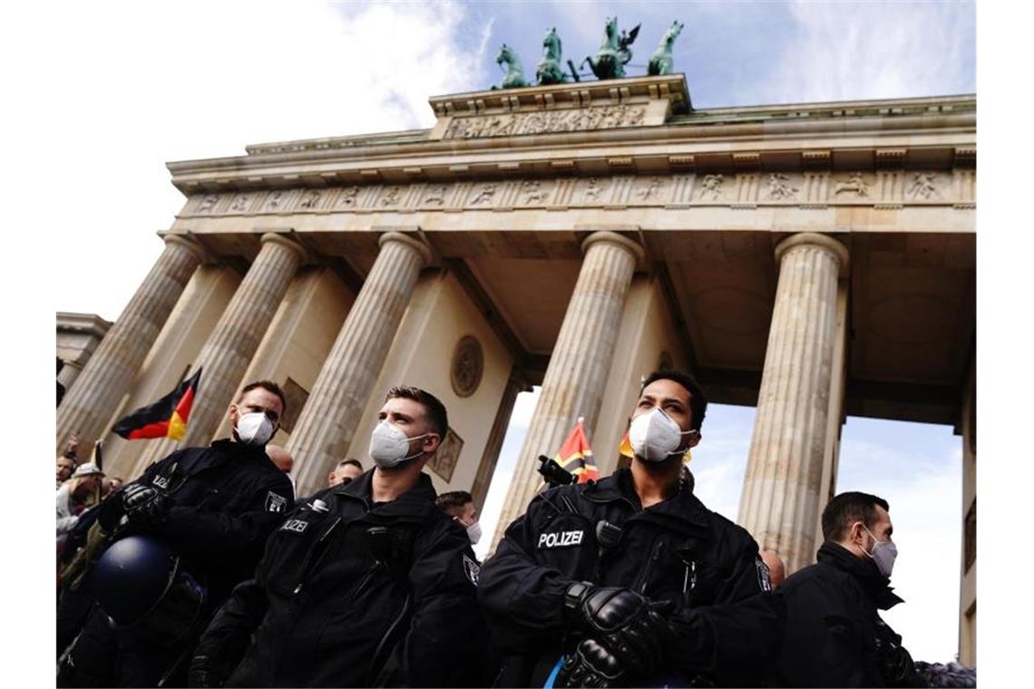 Polizisten mit Mundschutz vor dem Brandenburger Tor. Foto: Kay Nietfeld/dpa