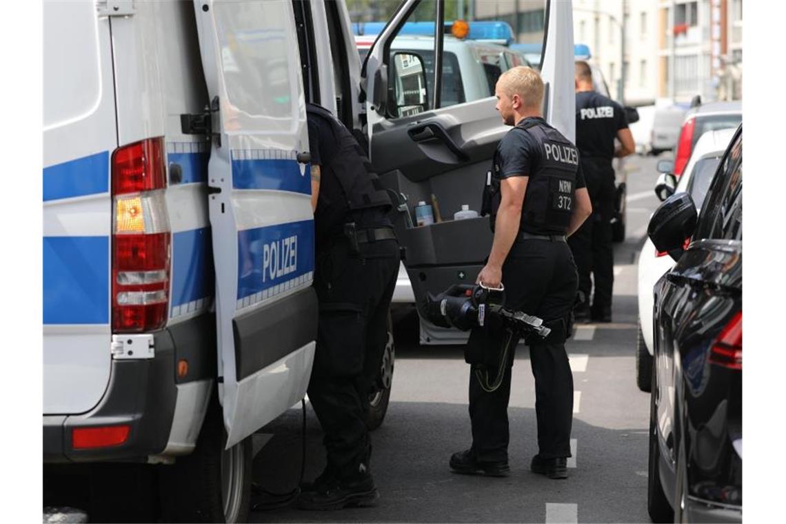 Polizisten mit Werkzeug nach der Durchsuchung. Foto: Oliver Berg