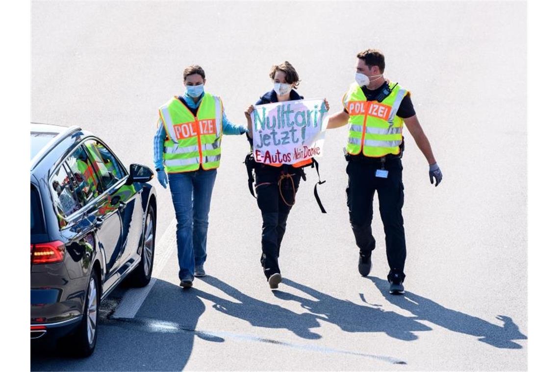 Polizisten nehmen auf der A9 eine Aktivistin fest. Foto: Matthias Balk/dpa