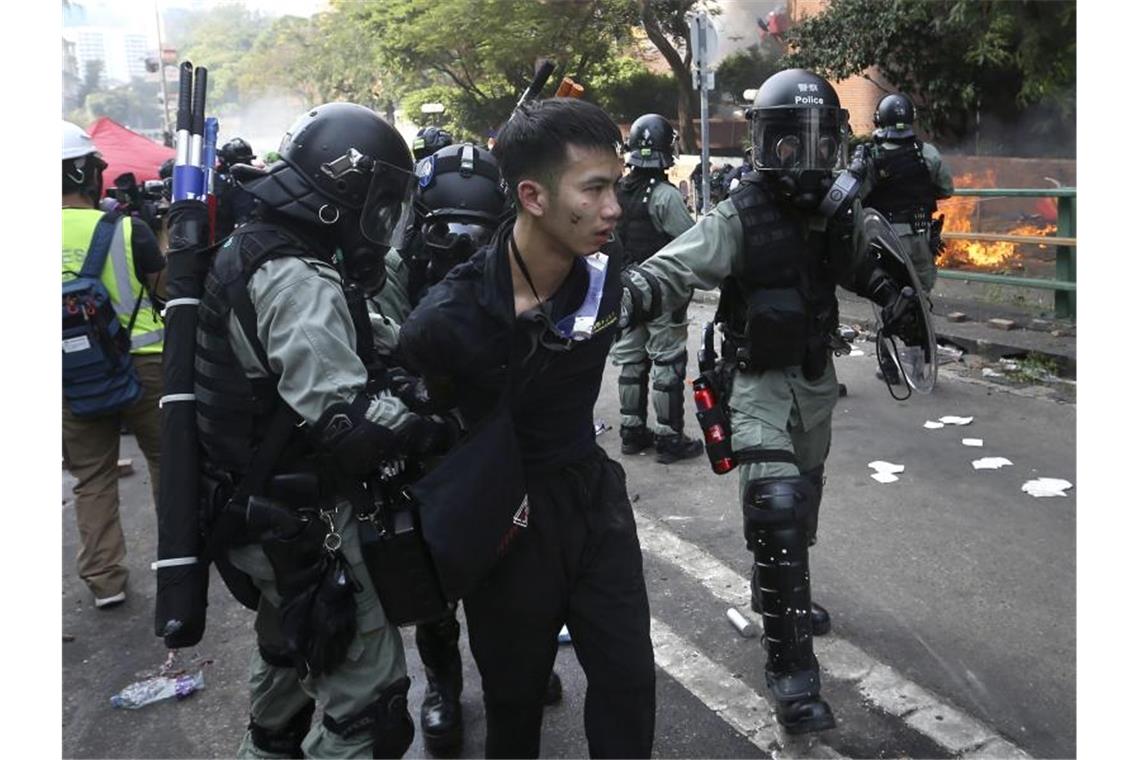 Polizisten nehmen einen Demonstranten fest. Foto: Achmad Ibrahim/AP/dpa