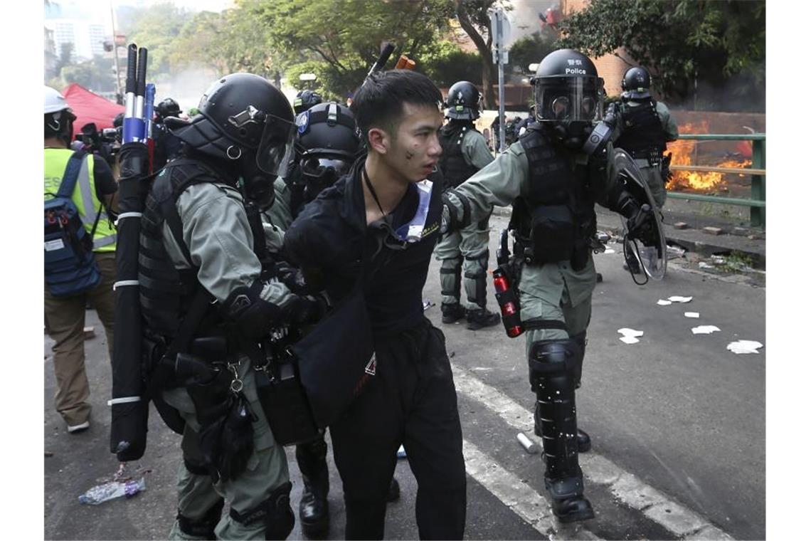 Hongkong: US-Kongress stellt sich hinter Demokratiebewegung Polizisten nehmen einen Demonstranten fest. Foto: Achmad Ibrahim/AP/dpa