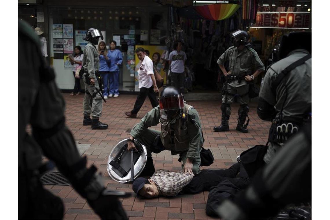 Erneut Demonstrationen und Krawalle in Hongkong Polizisten nehmen einen Demonstranten fest. Foto: Felipe Dana/AP/dpa