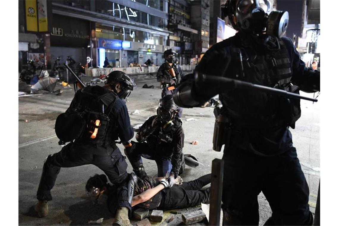 Hongkong: US-Kongress stellt sich hinter Demokratiebewegung Polizisten nehmen in der Nähe der Polytechnischen Universität einen Demonstranten fest. Foto: -/kyodo/dpa